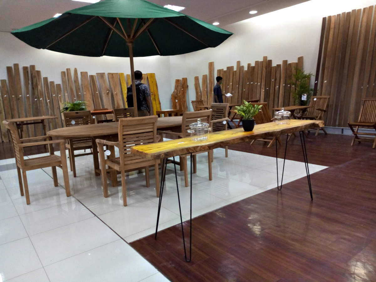 Meja sudut dengan tanaman cantik dan pot kayu sebagai hiasan dinding ruang tamu anda.