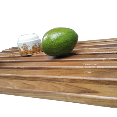 Flat plate dish drying rack with a cup and an avocado lying on it.