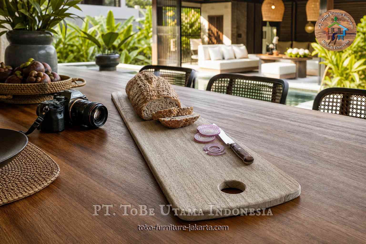 Long light-toned cutting board with bread, onion slices, and knife on an outdoor table by a pool