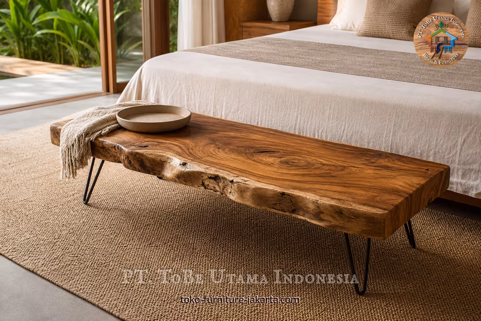 Meja samping tempat tidur kayu dengan tepi alami dan kaki hairpin hitam, diletakkan di kaki tempat tidur berwarna netral.